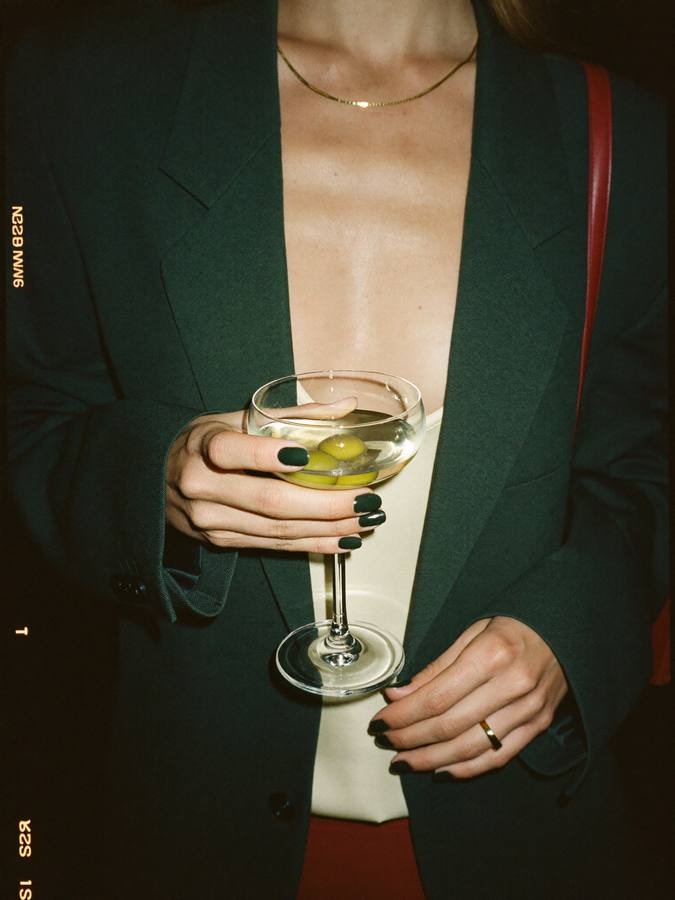 A guest in a green blazer with a coupe glass