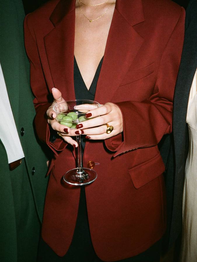 A guest in an oxblood blazer holding a martini